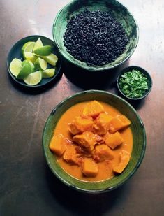 two bowls filled with food sitting on top of a table