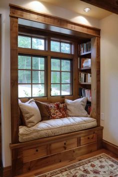 a window seat in the corner of a room with bookshelves on either side