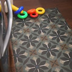 a close up of a mat with toys on it and a refrigerator in the background