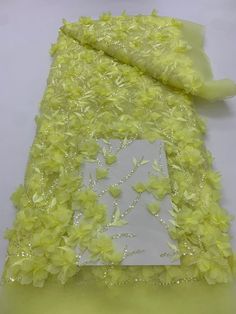 a piece of yellow fabric with flowers on the bottom and white paper in the middle