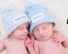 two babies are laying next to each other on a white furnishing floor wearing matching hats