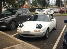 cars parked in a parking lot with eyes drawn on them