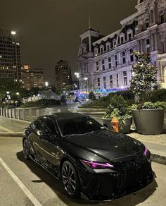 a black sports car parked on the side of the road in front of some buildings