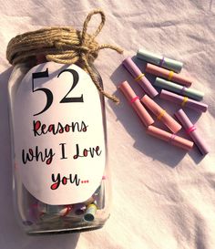 a jar filled with crayons next to a sign that says, 52 reasons why i love you