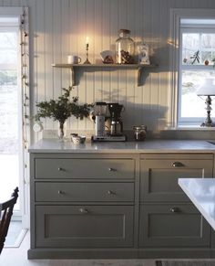 a kitchen with white walls and gray cabinets