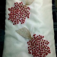 two red beaded leaves on white fabric