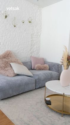 a living room with a couch, table and vase on the floor in front of it