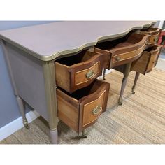 three drawers are open on the side of a desk in a room with carpeted flooring