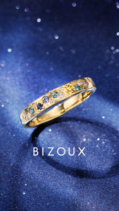 a close up of a ring on a blue surface with the words bizoux above it