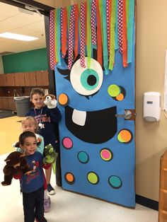 two children are standing in front of a door decorated with paper decorations and an evil monster