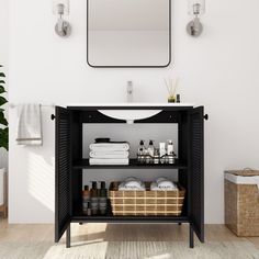 a bathroom with a black cabinet, mirror and white towels on the shelf next to it