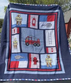 a quilted blanket with firemen and trucks on it