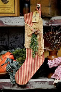 an old stocking hanging on a shelf next to other christmas ornaments and decorations,