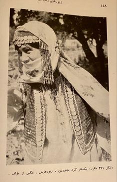 an old black and white photo of a woman wearing headdress in arabic writing