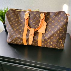 Louis Vuitton Monogram Keepall 45 Luggage Tote 100% Authentic Lv Brown And Tan Monogram Coated Canvas Louis Vuitton Keepall Bandoulire 45 With Brass Hardware Tan Vachetta Leather Trim Dual Rolled Top Handles Brown Canvas Lining And Two-Way Zip Closure At The Top Includes Luggage Tag And Strap Buckle Handle Drop 4" Height 10" Width 17.5" Depth 8" Excellent Condition No Visible Signs Of Wear Absolutely Flawless Bag. **** This Bag Cannot Be Bundled With Other Items For A Discount *** Please Look At Luxury Cognac Travel Bag For Weekend Trips, Designer Brown Travel Bag With Large Capacity, Designer Brown Rectangular Luggage, Designer Brown Luggage With Leather Trim, Designer Brown Travel Bag With Leather Handles, Designer Monogram Canvas Luggage For Everyday Use, Designer Brown Travel Bag, Designer Brown Leather Luggage, Designer Travel Bag With Gold-tone Hardware