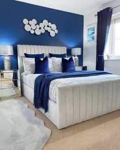 a bedroom with blue walls and white bedding