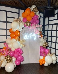 an arch made out of balloons and flowers