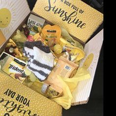 a yellow box filled with lots of food and gifts for someone's special occasion