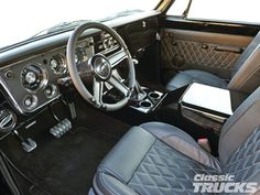 the interior of a classic car with black leather and chrome trims, including steering wheel