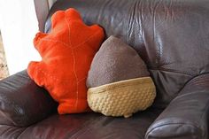 two pillows sitting on top of a brown leather couch