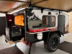 an off - road camper is parked in a garage with its doors open and the roof opened