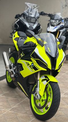 two yellow and black motorcycles parked next to each other