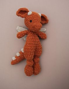 an orange crocheted stuffed animal with white wings