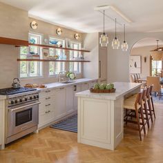 a kitchen with an island, stove and dining room table in the middle of it