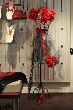 a mannequin with red flowers on display in a store