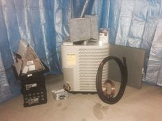 an air conditioner sitting on top of a floor next to other appliances and accessories