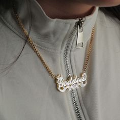 a woman wearing a gold necklace with the word love on it