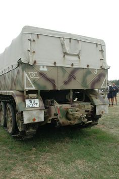 an army vehicle parked on top of a grass covered field