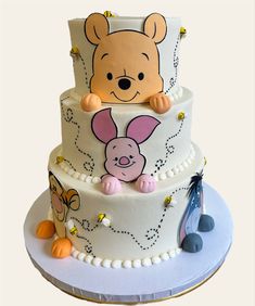 a three tiered cake decorated with winnie the pooh and music notes on it