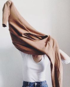 a woman is standing with her hands on her hips wearing a brown scarf over her head