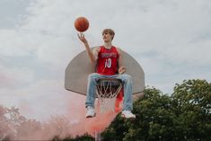 a man sitting on top of a basketball hoop