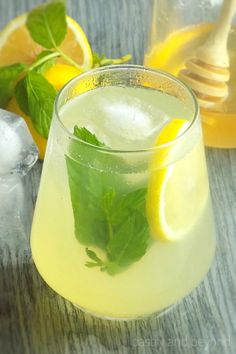 a glass filled with lemonade and mint on top of a table