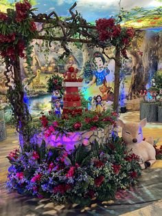 an elaborately decorated display with flowers and stuffed animals in the center, surrounded by other decorations