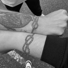 two people with tattoos on their arms holding onto each other