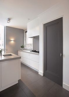 an image of a kitchen with white cabinets and grey doors