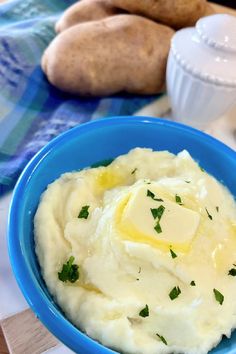 a blue bowl filled with mashed potatoes and butter