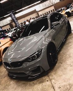 a silver car parked in a garage next to other cars