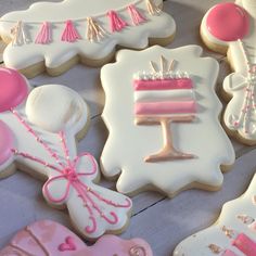 decorated cookies with pink and white icing are on the table next to each other