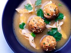 a bowl filled with soup and three meatballs