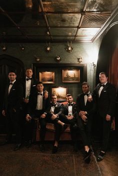 a group of men in tuxedos posing for a photo