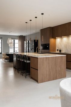 a modern kitchen with an island and bar stools