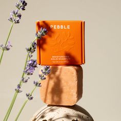 two soap bars stacked on top of each other with lavenders in the foreground