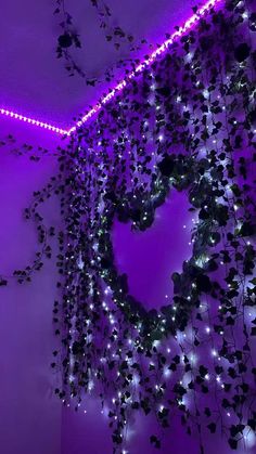 purple lights are hanging from the ceiling in a room with a heart shaped wreath on it