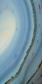 a close up view of the surface of an object with white and blue swirls