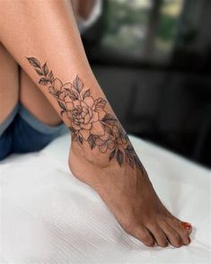 a woman with a flower tattoo on her foot