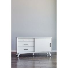 a white cabinet sitting on top of a hard wood floor next to a gray wall